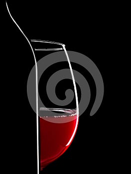 Elegant silhouette bottle of red wine and glass on black background