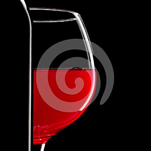 Elegant silhouette bottle of red wine and glass on black background