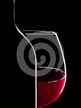 Elegant silhouette bottle of red wine and glass on black background