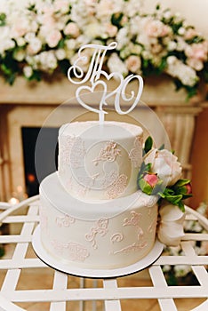 Elegant simple wedding cake with an ornate topper