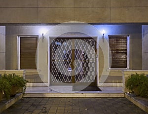 An elegant sixties apartment building`s main entrance framed glass door