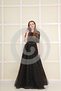 Elegant slim adult woman in fashion long evening lace black dress on white studio background, full length body