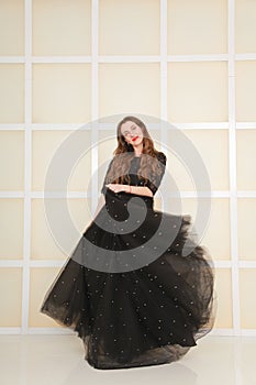 Elegant slim adult woman in fashion long evening lace black dress on white studio background, full length body