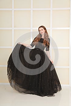 Elegant slim adult woman in fashion long evening lace black dress on white studio background, full length body