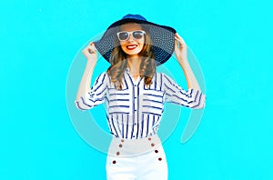 Elegant smiling woman wearing straw hat, white pants