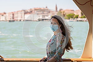 elegant solo tourist woman in floral dress riding vaporetto