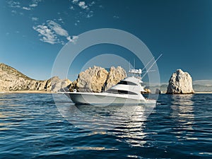 Elegant sportfishing yacht in the ocean in Cabo, Mexico sailing leisurely through a tranquil bay