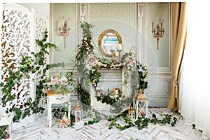 Elegant spring interior with flowers, ivy, fireplace and elegant furniture