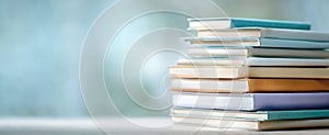 The elegant stack of books against a soft blue background. AI generated image