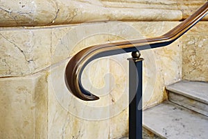Elegant stair railing in a museum or palace. Stone walls and shiny metal.