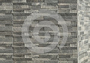 Elegant stone cladding wall made of gray granite panels with different shades and shapes.