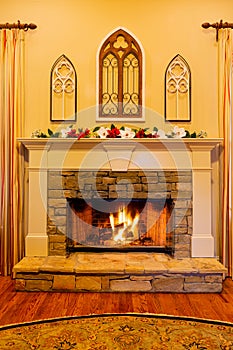 Elegant stone fireplace decorated with flowers for Christmas.