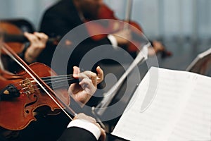 Elegant string quartet performing at wedding reception in restaurant, handsome man in suits playing violin and cello at theatre