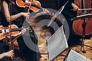 Elegant string quartet playing in luxury room at wedding reception in restaurant. group of people in black performing on violin