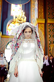 elegant stylish bride with floral kerchief in old church, wedding day in Lviv