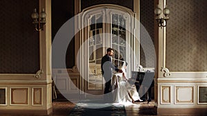 elegant stylish handsome groom looking at his gorgeous bride playing the piano. reflection in the mirror. unusual luxury wedding