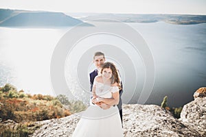 Elegant stylish happy wedding couple, bride, gorgeous groom on the background of sea and sky