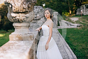 Elegant stylish sweet young beautiful happy bride girl woman in amazing wedding dress stands on the old palace. Wedding day