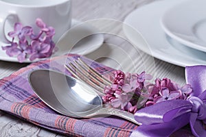 Elegant table setting for breakfast, with flowers lilacs