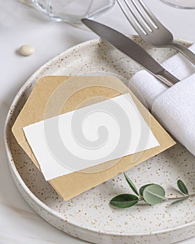 Elegant Table setting with a card decorated with eucalyptus branches close up, Wedding mockup