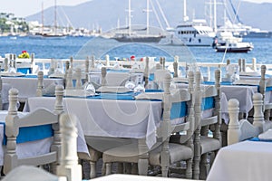 Elegant table setting with fork, knife, wine glass, white plate and blue napkin in restaurant . Nice dining table set with