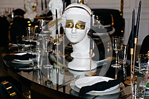 An elegant table setting graced with champagne glasses and a white marble bust of a female photo
