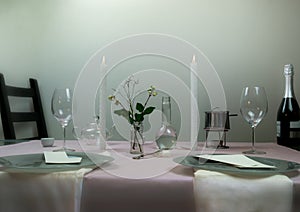 Elegant table setting. romantic dinner, wine glasses, flowers in a vase, candle