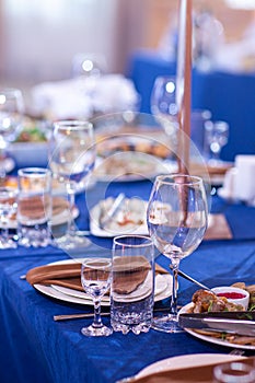 Elegant table setting white plates with napkins on blue tablecloth, tableware served empty table in a restaurant, Empty