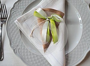 Elegant table with white dishes and wedding favors