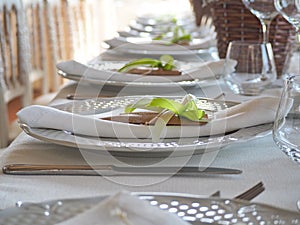 Elegant table with white dishes and wedding favorsElegant table with white dishes and wedding favors