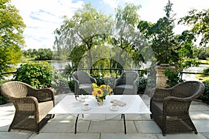 Elegant tea serving in garden with sunflowers in vase on marble table with silver tea pot and cookies