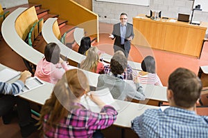 Elegant teacher with students at the lecture hall photo