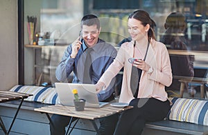 Elegant two young business people having an informal coffee meeting - Happy couple sitting on a cafe terrace flirting