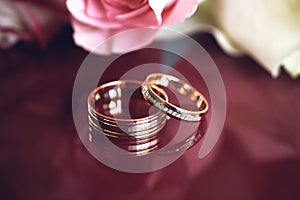 elegant wedding bouquet of white and pink rose flowers. gold wedding rings on the table. preparing for the wedding ceremony