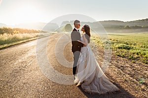 Elegant wedding couple stands tired on the road