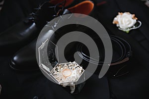 Elegant wedding rings for the bride and groom on a black background with highlights, macro, selective focus.