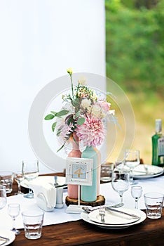 Elegant wedding table arrangement, floral decoration with peony, restaurant. Wedding table setup. Wedding in the forest.