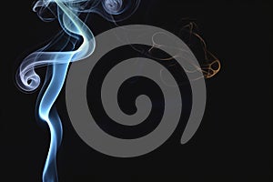 Elegant whisps of blue and white smoke against a dark background