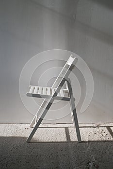 Elegant white chair in an empty room with concrete floor