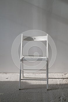 Elegant white chair in an empty room with concrete floor