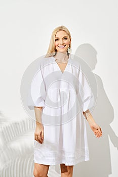 Elegant white dress on a cheerful model with shadow play