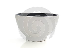 Elegant white empty ceramic bowl isolated on white background. Close up of a bright white and black cup
