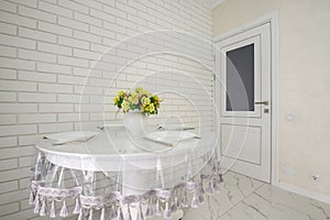 Elegant white round dining table in modern kitchen interior