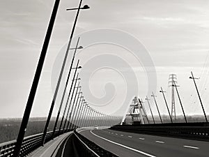 Elegant white steel arched bridge and highway with tilted street lights