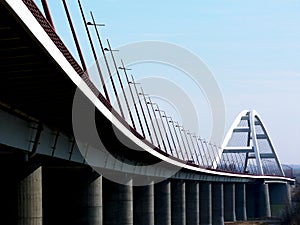 Elegant white steel arched bridge with tilted street lights