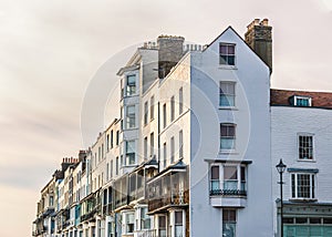 Elegant white Victorian terrace houses with ornate balconies and white rendering catching glow of the late afternoon winter sun