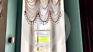 Elegant Window Drapes With Tassel Trim Overlooking. White sheer curtains with decorative tassels framing window