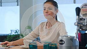 Elegant woman asking for a bill while sitting at cafe counter