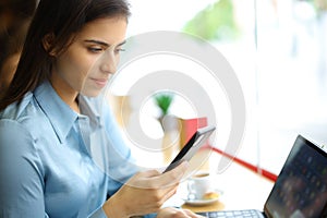 Elegant woman in a bar checking phone