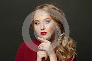 Elegant woman on black background. Model with make up and blonde curly hair